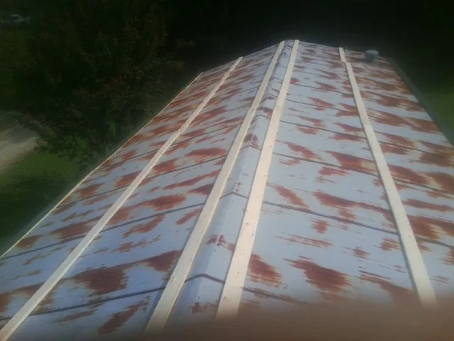 Rusted metal roof panels with new wood purlins before replacement — Storm Damage Roof Repair in Atmore by Roofing Brothers