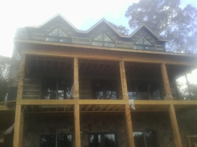 Dormers and porch framing on a large log home under construction — Roof Coating work by our crew in Atmore