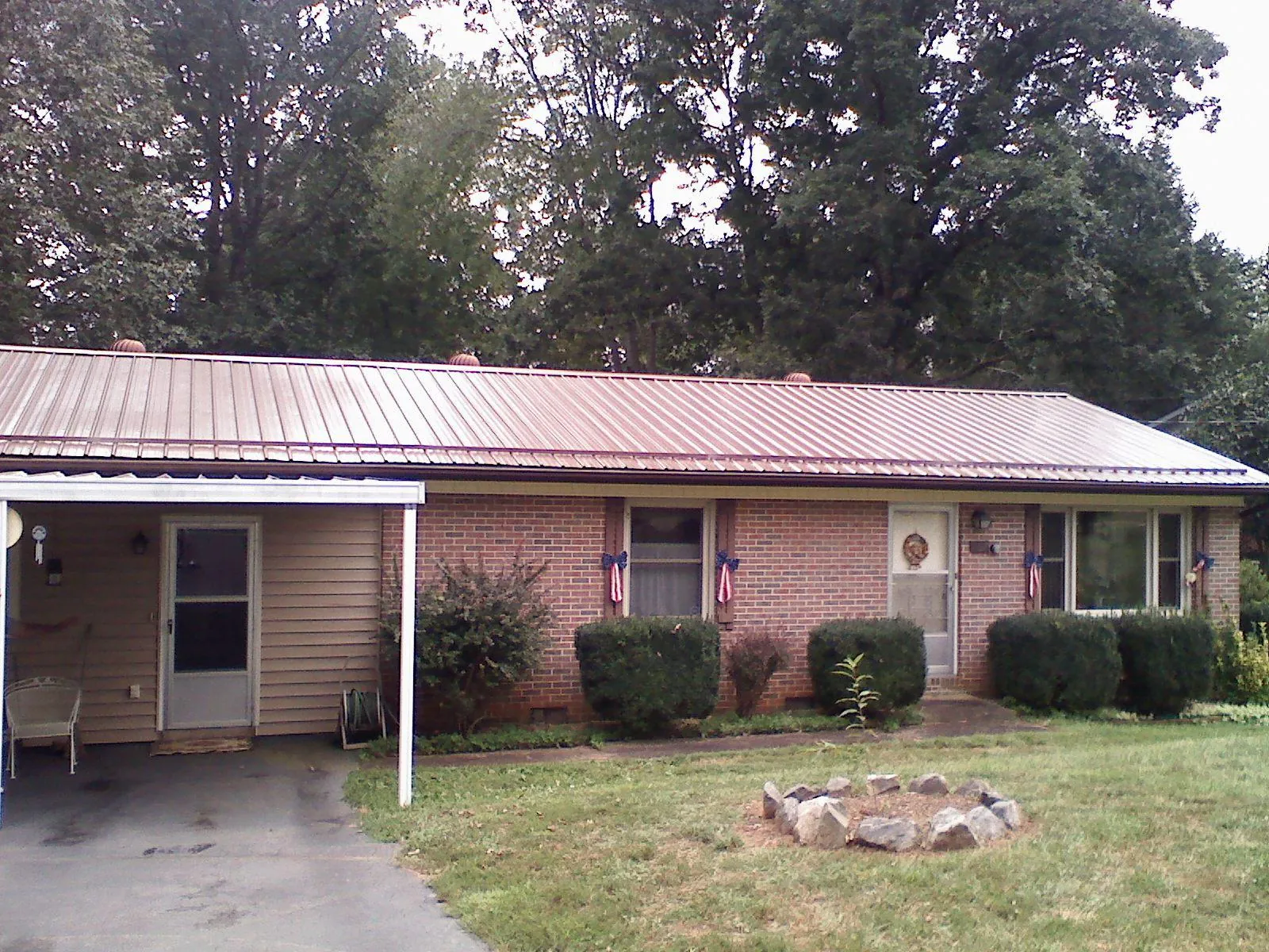Bronze metal roof and carport on a brick ranch home — Roof Repair work by our crew in Atmore