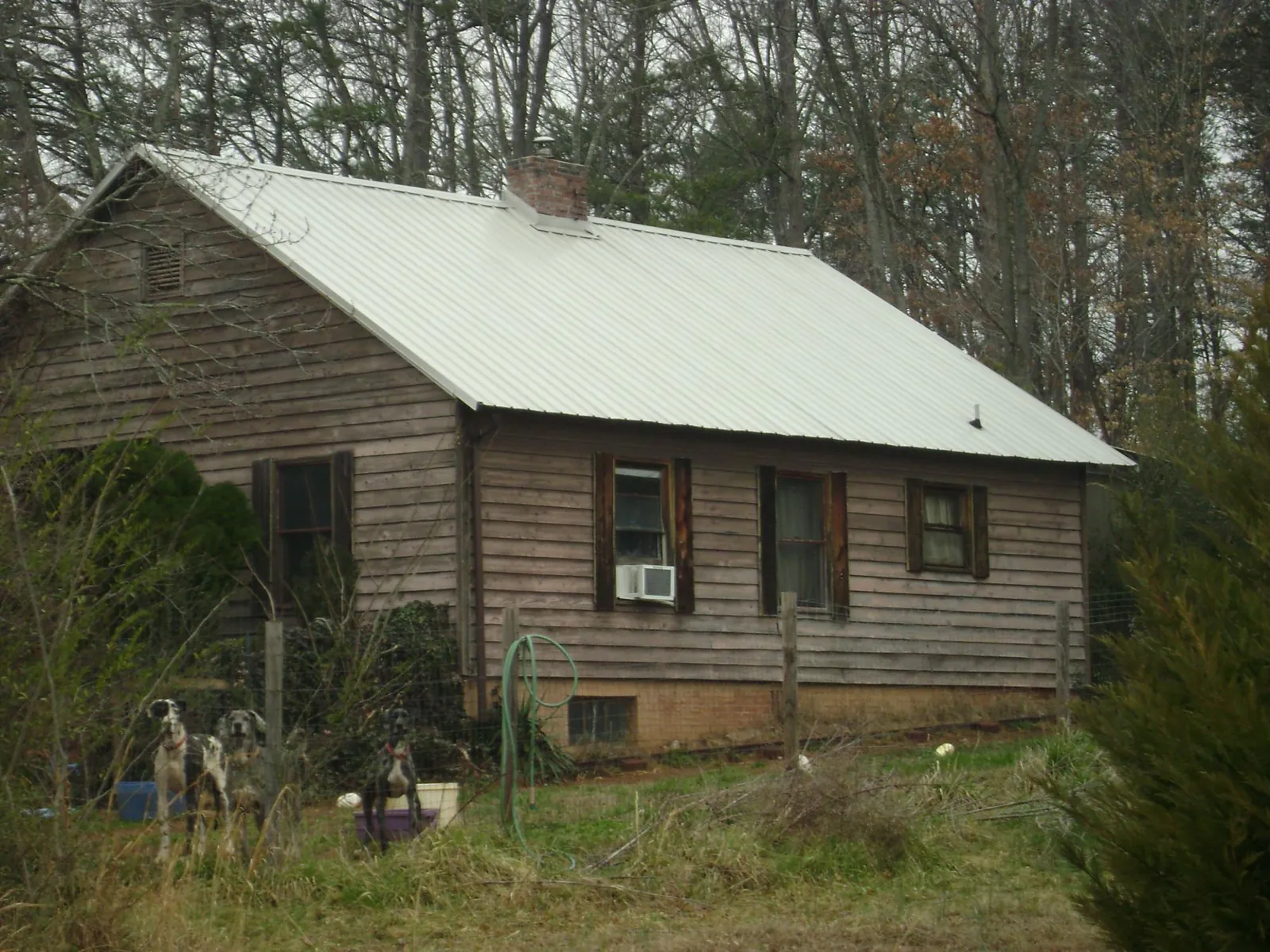 White metal roof on an old wood sided farmhouse, from a Asphalt Shingle Roof Repair job in Atmore
